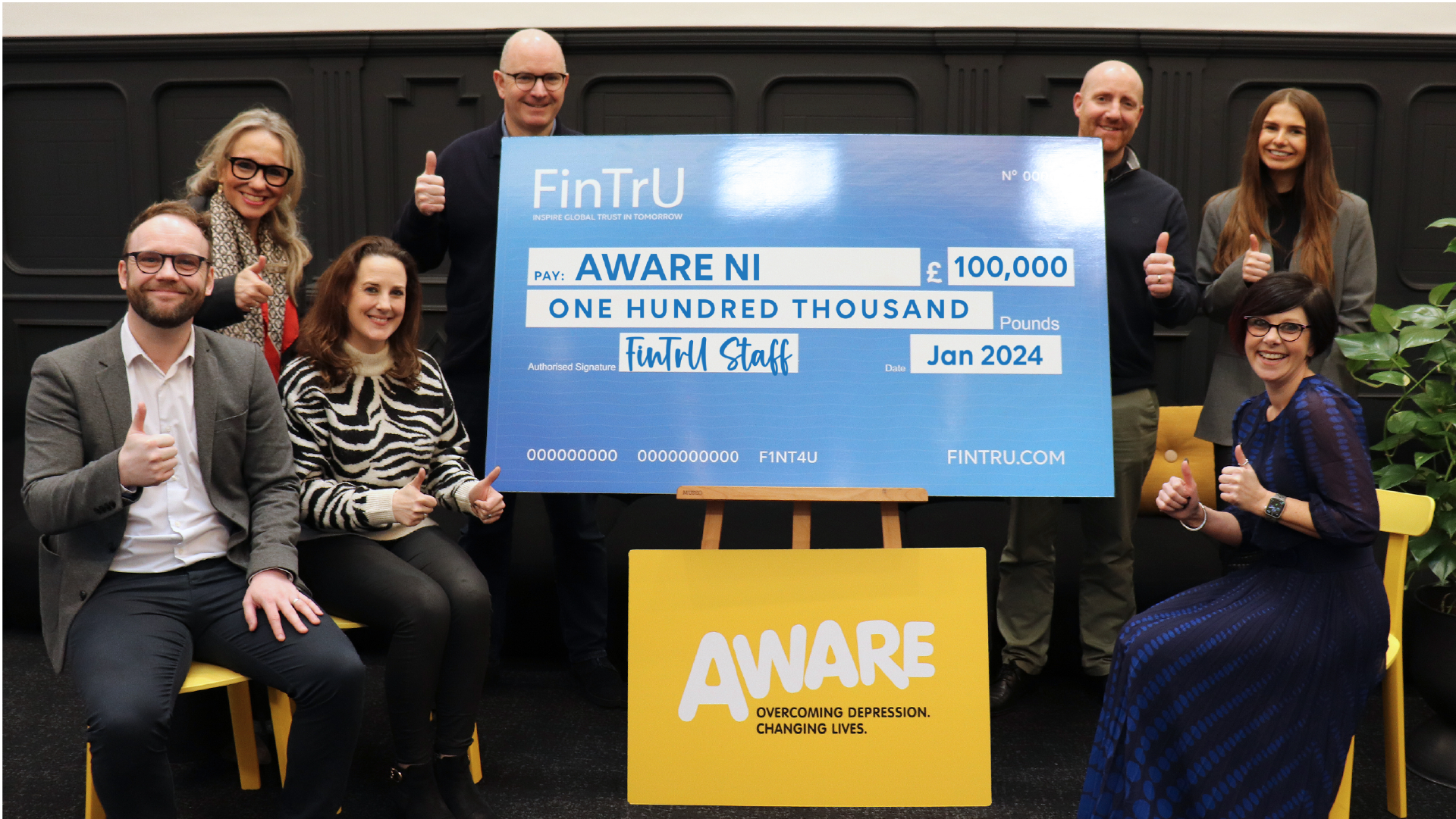FinTrU staff gives a one hundred thousand cheque to Aware