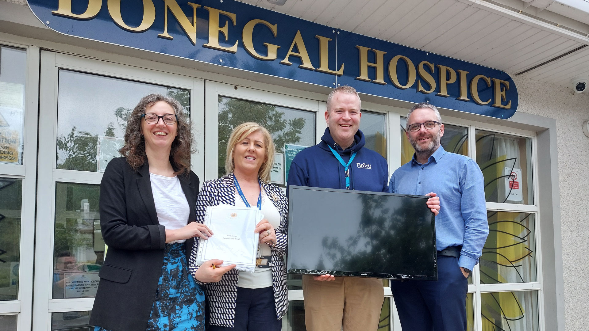 FinTrU employees and Isabel Rodgers in front of Donegal Hospice. Jamie holds a TV 