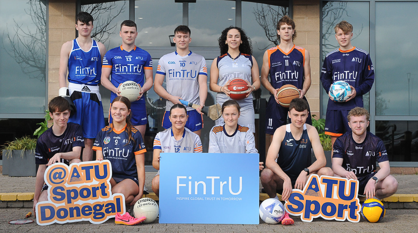 ATU Sport Donegal players in front of FinTrU building with two ATU and one FinTrU signage